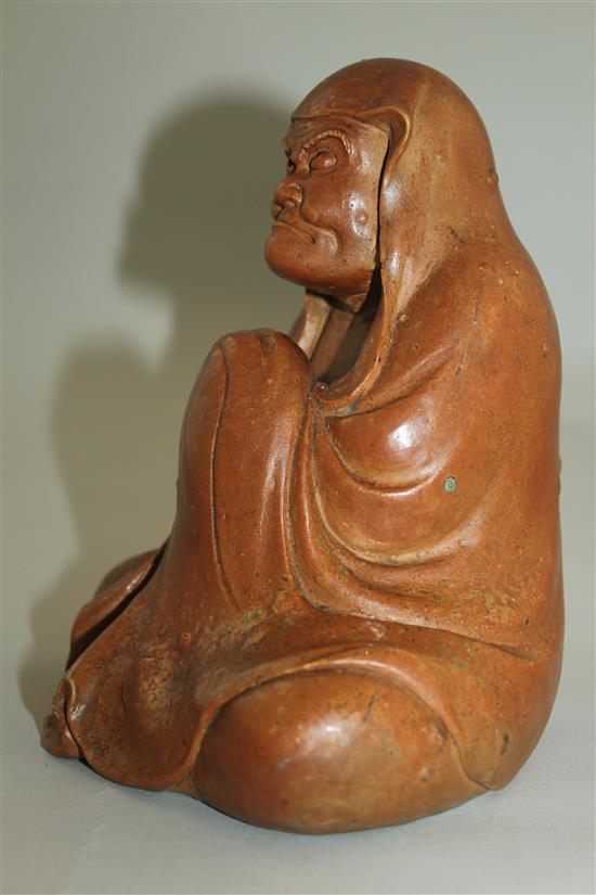 A Japanese stoneware seated figure of Daruma, 19th century, 18.5cm